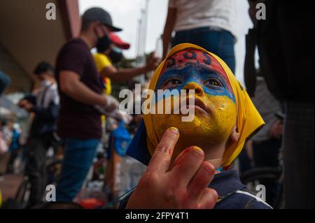 A small kid get his face painted with the message 'S.O.S' and the colors of the Colombian national flag as at least 12000 demonstrators gathered in no Stock Photo