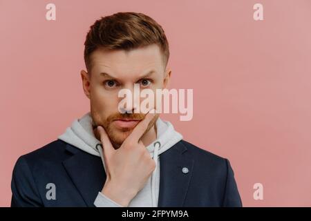 Concerned man holding touching chin and making decision Stock Photo