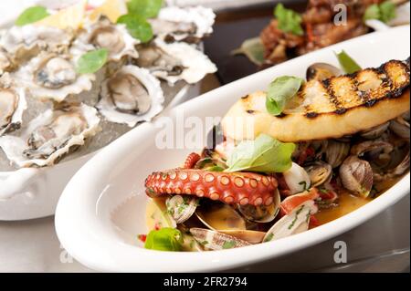 Seafood platter.  Oysters, clams, and octopus on ice at a Whistler Restaurant.  Whistler BC, Canada. Stock Photo