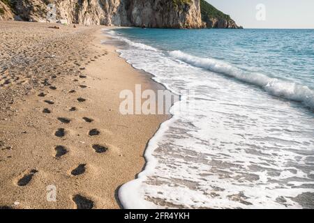 Foot steps on Milos beach near the Agios Nikitas village on Lefkada Ionian island, Greece. Stock Photo