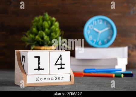 November 14th. November 14 wooden cube calendar with blur objects on background. Stock Photo