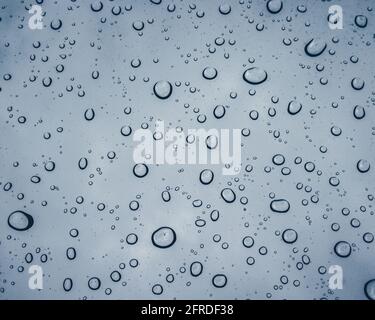 Rain droplets on a window during a spring rain storm Stock Photo
