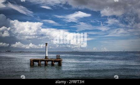 Looking out at Tokyo Bay with a lone pillar standing on a structure slowly being eaten by Tokay Bay near Yokosuka, Japan. Stock Photo