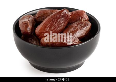 Dry pitted dates in a black bowl isolated on white. Stock Photo