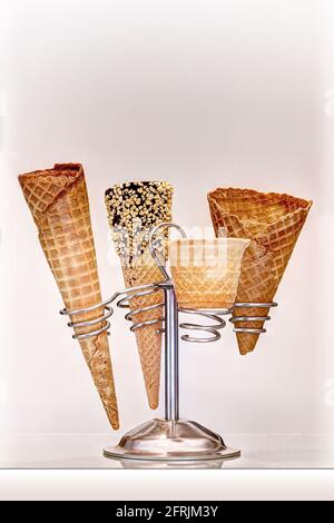 Ice cream cones of various types on beige background Stock Photo