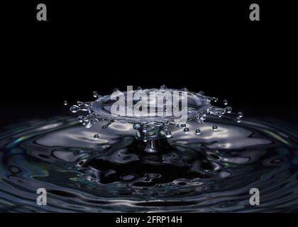 Collision ripple splash of two drops falling into the water. On a black Stock Photo