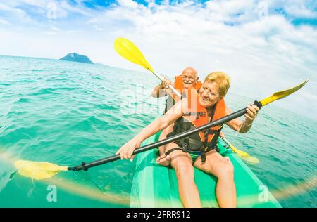 Senior happy couple taking travel selfie on kayak at Ang Thong marine park in Ko Samui - Trip to Thailand wonders - Active elderly concept