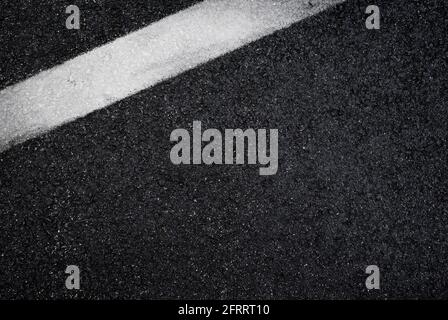 Top view of dark wet asphalt road with white line. High resolution full frame textured background of black asphalt, viewed from above. Copy space. Stock Photo
