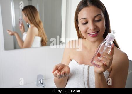 Happy beautiful woman holding cleansing oil. Beauty girl with ecological environmentally friendly makeup remover. Stock Photo