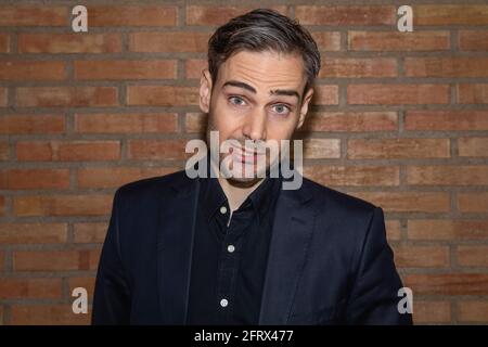 An influencer, artist and musician, speaks to the camera in one of his videos for social networks, while explaining his artistic career in a backstage Stock Photo