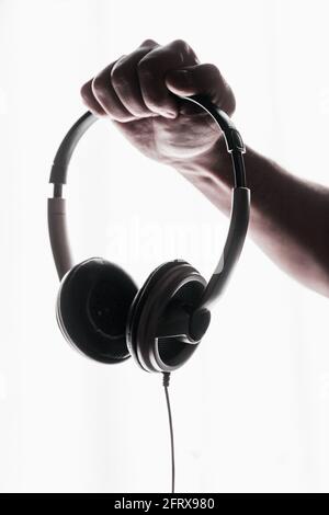Male hand holding headphones on white background Stock Photo