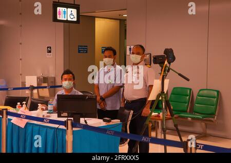 2 Thai health officials & a security guard, wearing protective face masks, man the Thermoscan at Suvarnabhumi International Airport during the coronavirus epidemic. Bangkok, Thailand. Feb. 27th, 2020. © Kraig Lieb Stock Photo