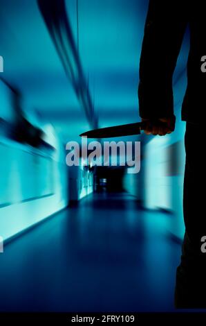 mysterious man silhouette with a knife in hand Stock Photo