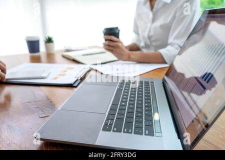 young business team in casual style have small meeting in the office talk about  analyses chart graph marketing plan with computer laptop calculator a Stock Photo