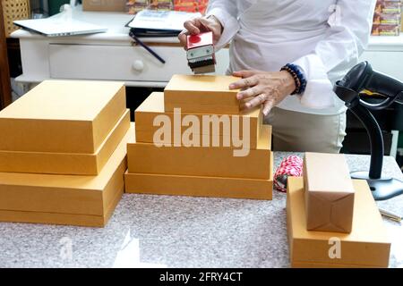 Small business woman Worker delivery service and working packing box, business owner working checking order to confirm before sending customer in post Stock Photo