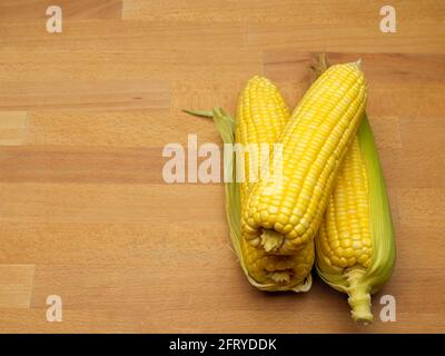 Top view of corns and corn on the cop isolated on wooden table with copy space Stock Photo