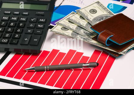 Banknotes, charts and a pen on the office table. Financial indicators of profit growth. Company statistics, research and analytics. Banking, tax calcu Stock Photo