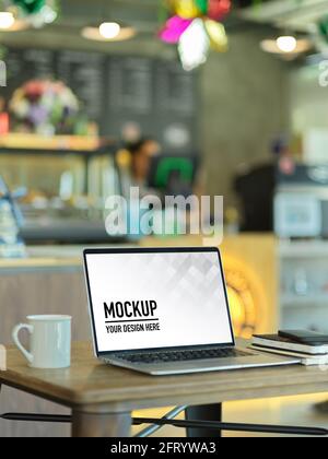 Cropped shot of portable workspace with laptop and coffee mug in cafe Stock Photo