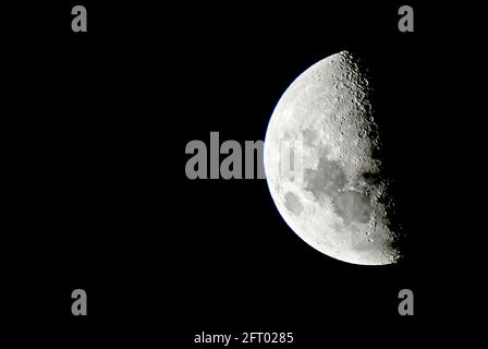 Moon hangs close in the midnight sky Stock Photo