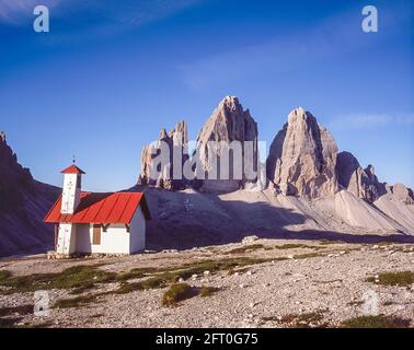 Italy. The image is of the climber chapel at the Drei Zinnen Hut [Rifugio Locatelli] looking towards the famous Three Towers, known in German as Drei Zinnen but more poetically named in Italian as the Tre Cime di Laverado located in the Sexten-Sesto eastern region of the Italian Dolomites. During the First World War, known as the White War the peaks provided a natural barrier between the  Italians and the warring Austrians, the front line running through the peaks. Stock Photo