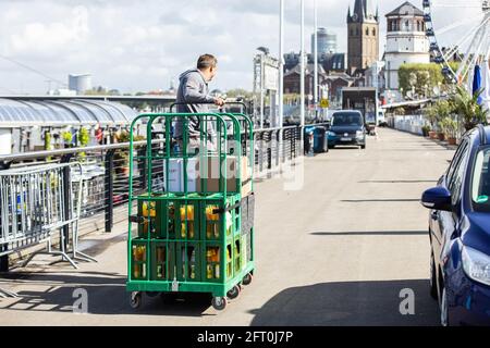 Duesseldorf, Germany. 21st May, 2021. An employee of a catering business moves crates of drinks along the casemates on the banks of the Rhine. After a month-long forced break, restaurateurs in Düsseldorf will be allowed to welcome guests again from Friday. As in other municipalities in NRW, this only applies to the outdoor area. Credit: Marcel Kusch/dpa/Alamy Live News Stock Photo