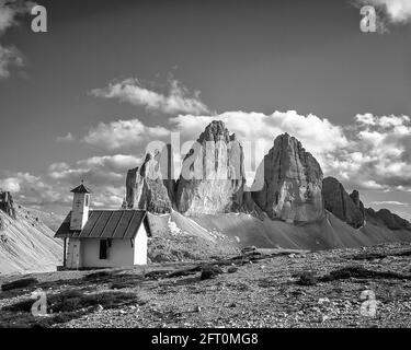 Italy. The image is of the climber chapel at the Drei Zinnen Hut [Rifugio Locatelli] looking towards the famous Three Towers, known in German as Drei Zinnen but more poetically named in Italian as the Tre Cime di Laverado located in the Sexten-Sesto eastern region of the Italian Dolomites. During the First World War, known as the White War the peaks provided a natural barrier between the  Italians and the warring Austrians, the front line running through the peaks. Stock Photo