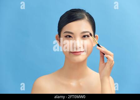 Beautiful and professional make up artist using brush and blusher Stock Photo