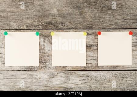 Sticky notes with pins in a row on a wooden background. Space for text, free space, top view Stock Photo