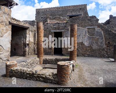 The tetrastyle atrium with four brick columns sustaining the inner margins of the roof. The central impluvium has a raised masonry surround with a fluted marble puteal on its southern side. The walls of the atrium, like those of the fauces, retain a few plaster remnants but no decorative detail. House of the Cryptoporticus (Casa del Criptoportico) - Pompeii archaeological site, Italy Stock Photo