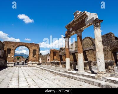 Honorary arch of Tiberius and fragments of the Corinthian columns belonging to the Macellum or food market in the forum - Pompeii archaeological site, Italy