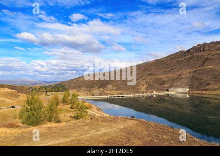 The Clyde Dam, a hydroelectric dam on the Clutha River near the town  of Clyde, New Zealand. Behind it is Lake Dunstan Stock Photo