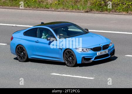 2015 blue BMW M4 S-A 2979cc 2dr coupe; Vehicular traffic, moving vehicles, cars, vehicle driving on UK roads, motors, motoring on the M6 motorway highway UK road network. Stock Photo