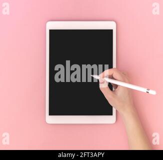 Woman using tablet with stylus mockup with blank screen, top view and pink colorful background Stock Photo