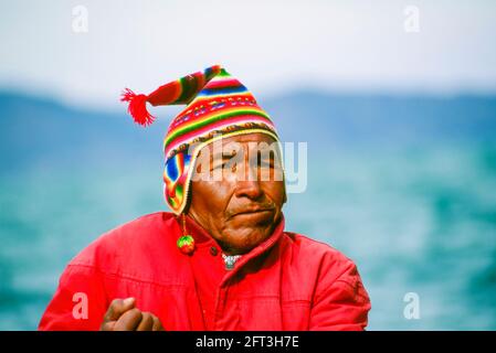 Close-up portrait of a local Peruvian man, a boatman on Lake Titicaca on a trip from Puno to Taquile Island, wearing a red traditional knitted cap Stock Photo