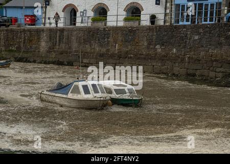 Cornwall, UK. May 21 2021: Porthleven Cornwall strong winds cause seafoam, to cover boats in the harbour, locals still swim, Cornish snow Credit: kathleen white/Alamy Live News Stock Photo