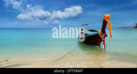 view of limestone island and long tail boat in phang nga bay in thailand Stock Photo