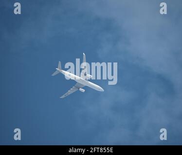 A commercial passenger plane flies above the clouds Stock Photo