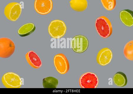 Minimal idea with fresh orange, lemon, lime and grapefruit sliced on a ultimate gray background. Minimal concept with several different types of citru Stock Photo