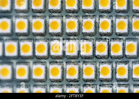 Close-up macro view of led smd bulb lamp with rows of yellow diode light components panel. Tech abstract texture pattern background electronic Stock Photo