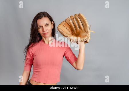 Portrait of slender woman holding big baseball glove in her hand. Sports game, active life Stock Photo