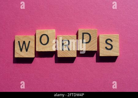 Words, word in wooden alphabet letters isolated on pink background as banner headline Stock Photo