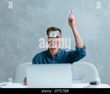 Satisfied man with raised hand thinking about good creative idea. Stock Photo