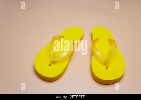 yellow slippers on a sand-colored background. Copy space Stock Photo