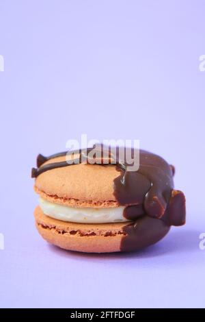 chocolate Cake macaron or macaroon on purple background. colorful almond cookies. French macaroon cake close-up. Macaroons on colored background Stock Photo