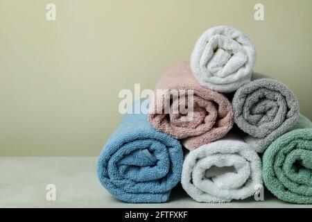 Clean rolled towels against beige background, space for text Stock Photo