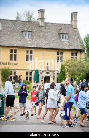 Crowds in the Cotswold village of Bourton-on-the-Water which is experiencing unprecedented visitor numbers during the Coronavirus pandemic Stock Photo