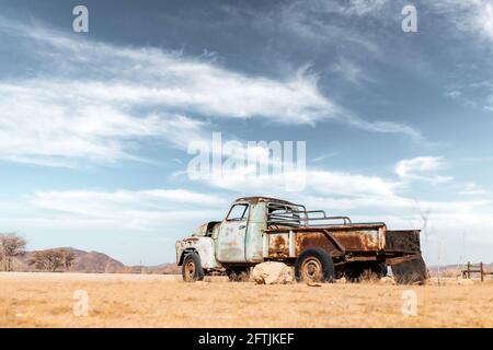 Abandoned derelict old car in the sandy desert Stock Photo