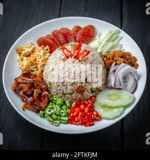 A Dish of Thai Stir-Fried Rice with Shrimp Paste on Black Wooden Background Stock Photo