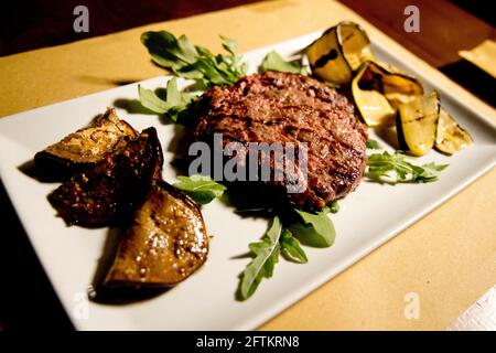 hamburger served on a plate with a side of vegetables Stock Photo