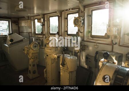 Navigational bridge on abandoned vessel. Old derelict ship wheelhouse. Ship's control device. Russian words: Ahead/Astern, full, half, slow, dead slow Stock Photo